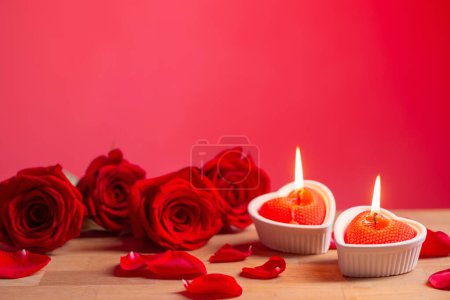 Photo for Red roses with burning candles on red background - Royalty Free Image