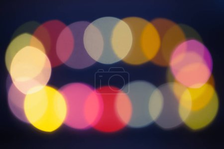 Foto de Bokeh multicolor de luces de Navidad sobre fondo oscuro - Imagen libre de derechos