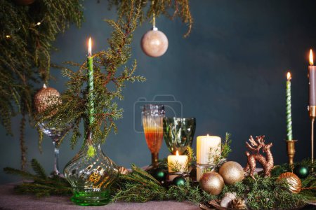 Foto de Decoración de Navidad verde y dorada en la mesa sobre fondo oscuro - Imagen libre de derechos
