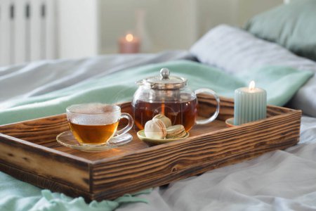 Foto de Té en bandeja de madera en la cama en casa - Imagen libre de derechos