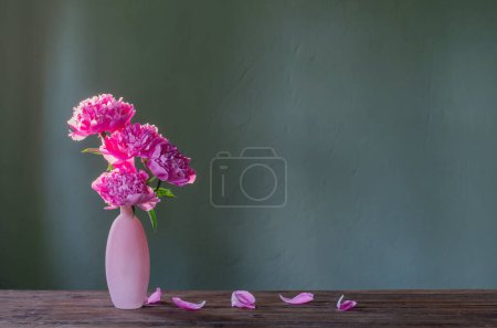 Téléchargez les photos : Pivoines roses dans un vase rose sur fond vert - en image libre de droit