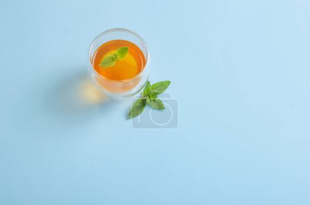Téléchargez les photos : Thé à la menthe et origan sur fond bleu - en image libre de droit