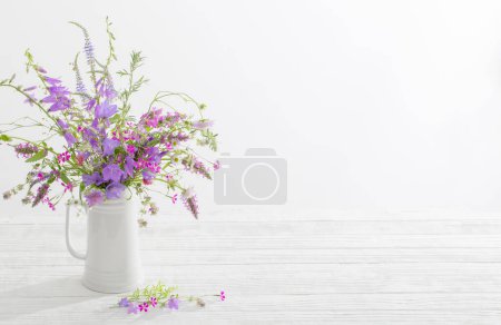 Téléchargez les photos : Fleurs sauvages d'été en cruche blanche sur fond blanc - en image libre de droit