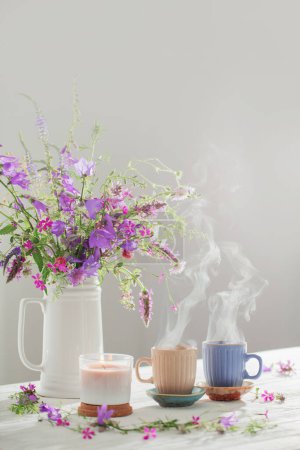 Téléchargez les photos : Tisane aux fleurs sauvages d'été sur table blanche en bois - en image libre de droit