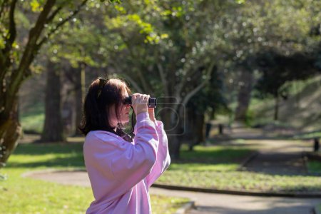Foto de Mujer joven con binocular en el parque de primavera - Imagen libre de derechos