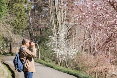 Photo for Man with binocular in spring sunny park - Royalty Free Image