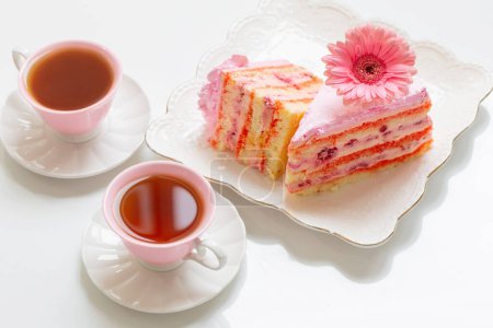 Foto de Dos tazas de té con pastel rosa en la mesa blanca - Imagen libre de derechos