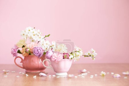 Photo for Beautiful spring flowers in two vintage cups on pink background - Royalty Free Image