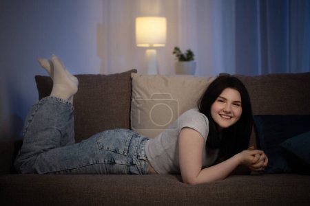 Foto de Adolescente morena chica en sala de estar por la noche - Imagen libre de derechos