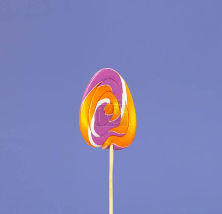 Foto de Bastones de caramelo de Pascua en forma de huevos sobre fondo púrpura - Imagen libre de derechos