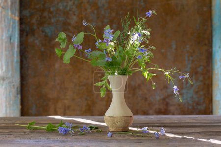 Téléchargez les photos : Fleurs sauvages dans un vase sur fond vieux mur - en image libre de droit