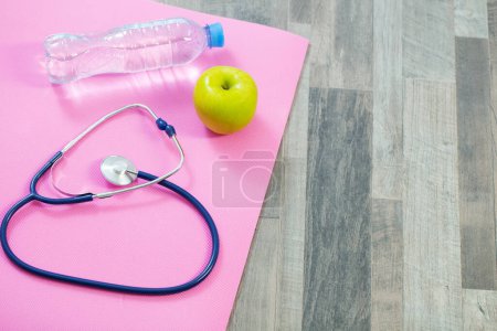 Téléchargez les photos : Stéthoscope sur tapis de fitness, concept de santé cardiaque - en image libre de droit