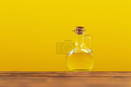 Photo for Cooking oil in glass bottle on yellow background - Royalty Free Image