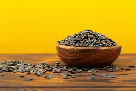 Photo for Black sunflower seeds on  wooden table - Royalty Free Image
