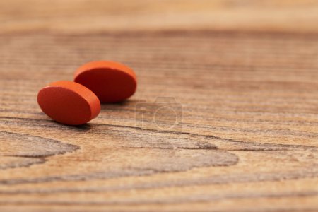 Photo for Two pills on old wooden background - Royalty Free Image