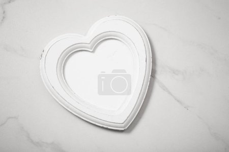 Téléchargez les photos : Cadre en bois en forme coeur sur fond de marbre blanc - en image libre de droit