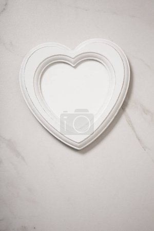 Photo for Wooden frame in form heart on white marble background - Royalty Free Image