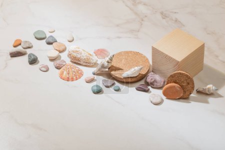 Foto de Podio de madera con piedras de mar sobre fondo de mármol - Imagen libre de derechos