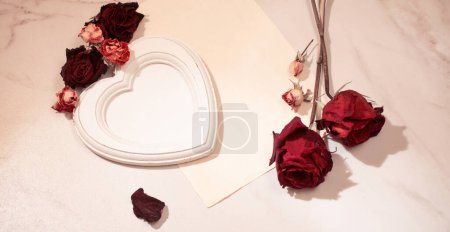 Foto de Marco de madera con rosas rojas secas sobre fondo de mármol - Imagen libre de derechos