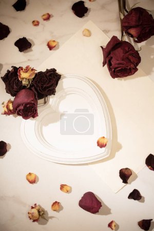 Téléchargez les photos : Cadre en bois avec des roses rouges séchées sur fond de marbre - en image libre de droit