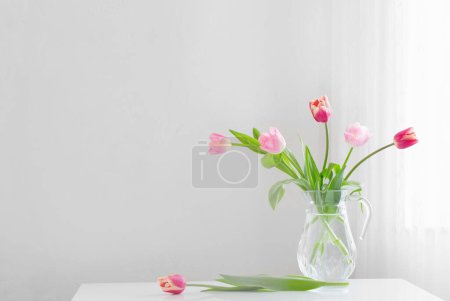 Téléchargez les photos : Tulipes dans un vase en verre sur fond blanc - en image libre de droit