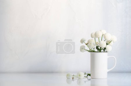 Téléchargez les photos : Chrysanthèmes blancs dans une tasse vintage sur fond blanc - en image libre de droit