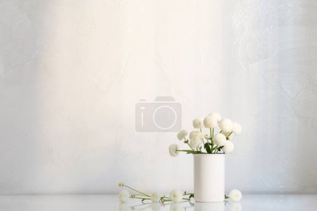 Téléchargez les photos : Chrysanthèmes blancs dans un vase sur fond blanc - en image libre de droit