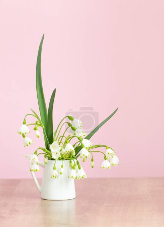Téléchargez les photos : Fleurs blanches de printemps en cruche sur fond rose - en image libre de droit