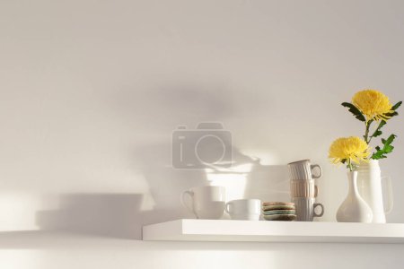 Photo for Yellow chrysanthemum in vase and cups on white shelf on white background - Royalty Free Image