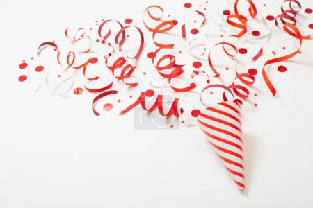 Foto de Sombrero de cumpleaños rayado con confeti sobre fondo blanco - Imagen libre de derechos