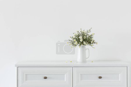 Photo for White flowers in white ceramic vase in white interior - Royalty Free Image