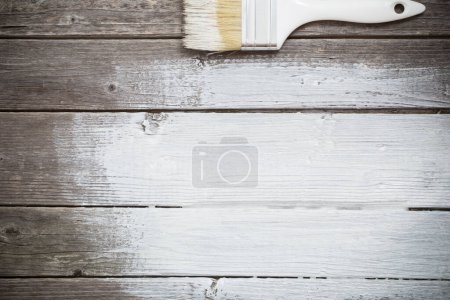 Foto de Pincel con pintura blanca sobre fondo de madera viejo - Imagen libre de derechos