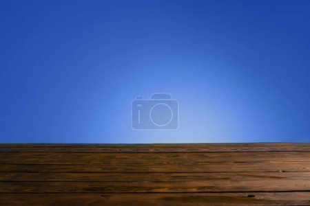 Photo for Dark woodewn table on background bright blue wall - Royalty Free Image