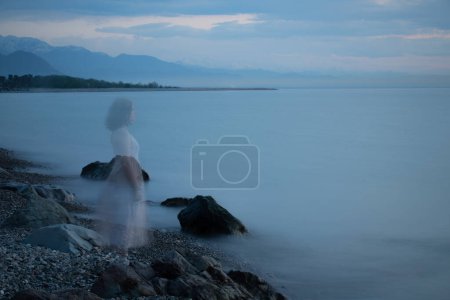 Foto de Joven chica triste en vestido blanco por mar - Imagen libre de derechos