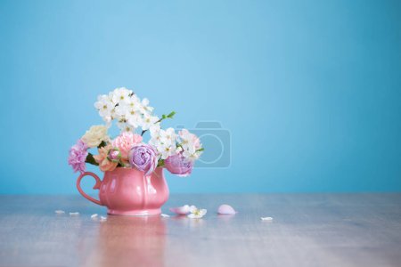 Téléchargez les photos : Belles fleurs printanières en coupe vintage aux couleurs pastel sur fond bleu - en image libre de droit