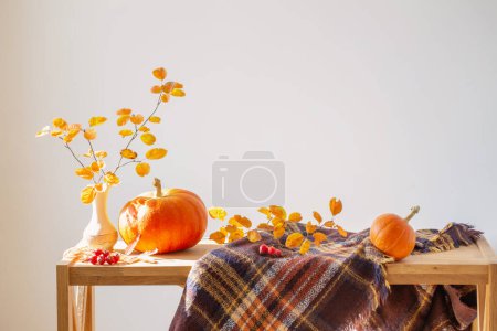 Téléchargez les photos : Branches d'automne avec des feuilles orange dans un vase et des citrouilles sur fond blanc - en image libre de droit