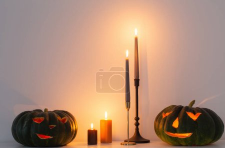 Foto de Calabaza de halloween negro con velas encendidas en el interior blanco - Imagen libre de derechos
