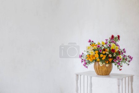 Téléchargez les photos : Bouquet de chrysanthèmes colorés dans un vase sur fond blanc vieux mur - en image libre de droit