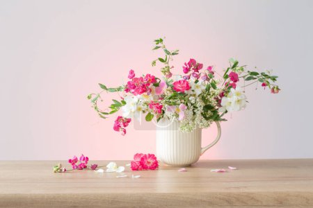 Foto de Flores de verano en taza de cerámica sobre fondo claro - Imagen libre de derechos