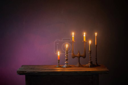 Foto de Velas encendidas en candelabros antiguos sobre fondo oscuro - Imagen libre de derechos