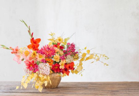 Téléchargez les photos : Bouquet d'automne avec des fleurs rouges et jaunes dans un vase en céramique sur fond blanc - en image libre de droit