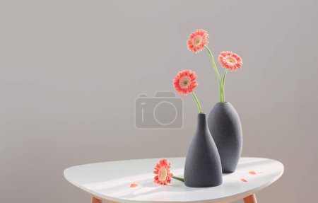 Foto de Gerber rosa en jarrones grises sobre mesa blanca sobre pared gris de fondo - Imagen libre de derechos