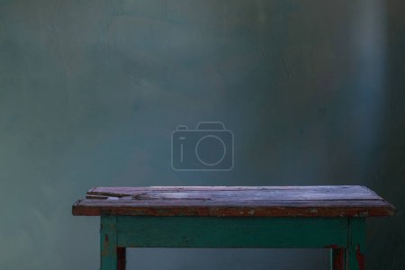 Téléchargez les photos : Vieille table en bois sur fond vieux mur vert - en image libre de droit