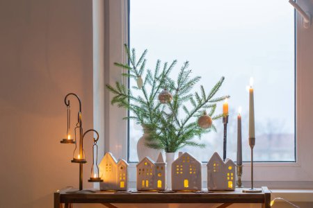 Foto de Hermosa habitación blanca con decoración de Navidad con velas encendidas - Imagen libre de derechos