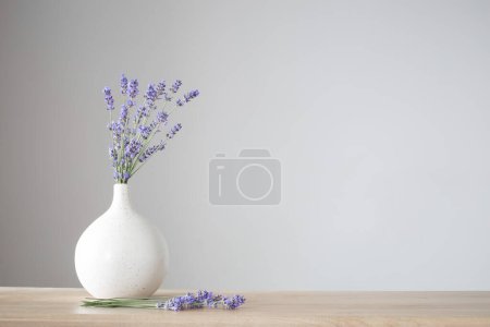 Téléchargez les photos : Fleurs de lavande dans un vase en céramique sur fond gris - en image libre de droit