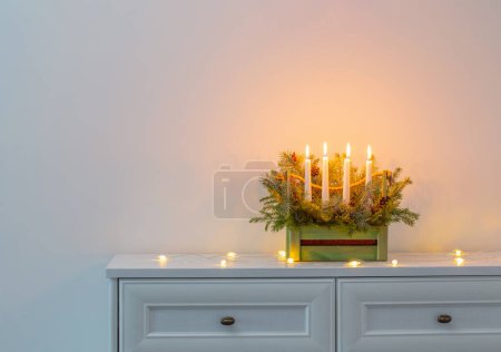 Photo for Advent decoration with fir branches and four burning candles in wooden basket on white background - Royalty Free Image