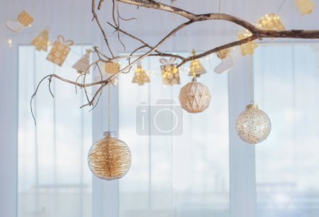 Photo for Christmas balls on golden branch on background window - Royalty Free Image