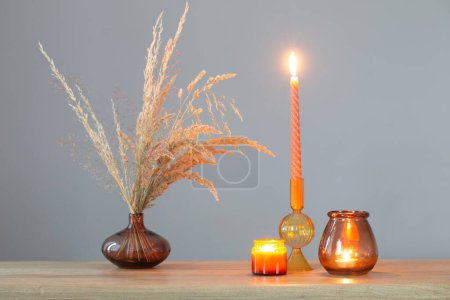 Photo for Dried flowers and burning candles on background dark wall - Royalty Free Image