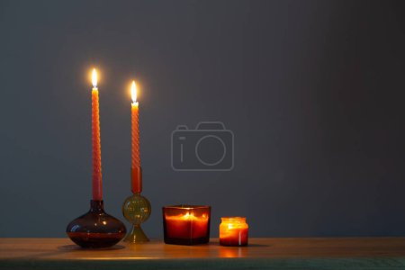 Photo for Burning candles in glass candlesticks on dark background - Royalty Free Image