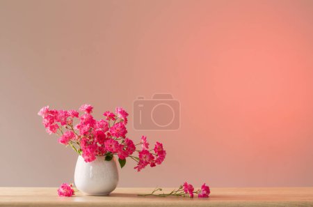 Téléchargez les photos : Roses roses dans un vase en céramique sur fond rouge clair - en image libre de droit